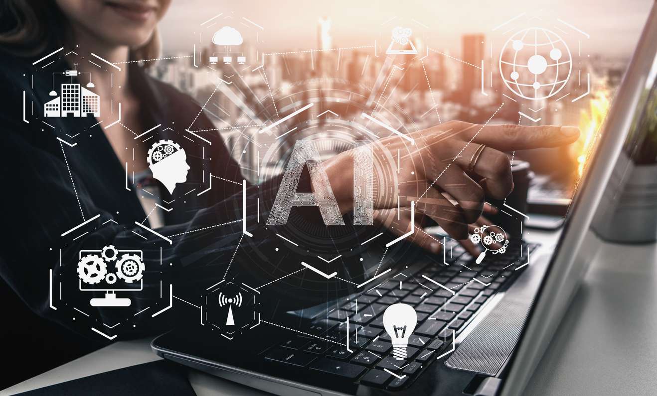 Woman pointing to a laptop screen with icons on virtual screen to suggest AI in background screening.